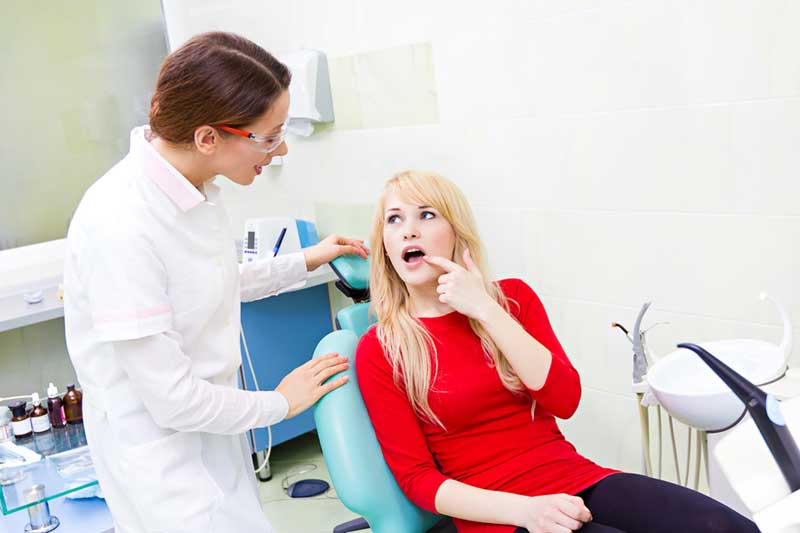 Patient Showing Her Painful Teeth to Doctor