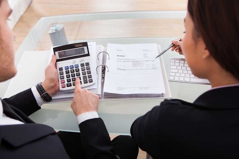 Man and Woman are Working with Calculator and Documents